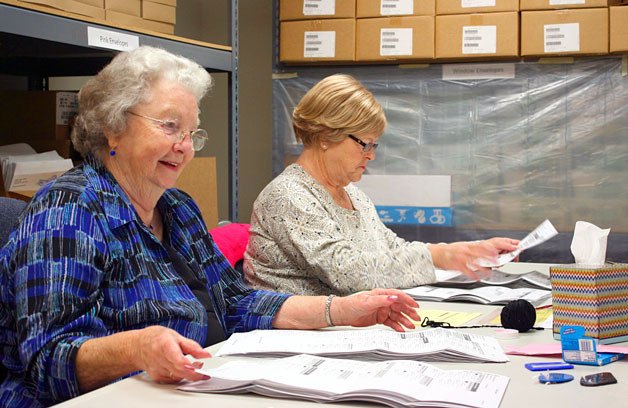 Dodie Hanby (left) and her coworkers help the county auditor’s elections office process incoming ballots for the August primary