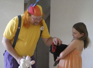“Clucky” — aka comedian Matt Hoar — pets Henry the chicken as Violette Morant looks on. Hoar will present three vaudeville shows a day at the fair to encourage folks to visit the poultry barn.