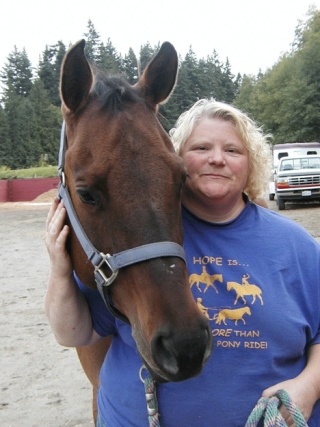Hometown Hero Denise Boyett stands with one of her horse friends at the HOPE riding facility at the Island County Fairgrounds in Langley.