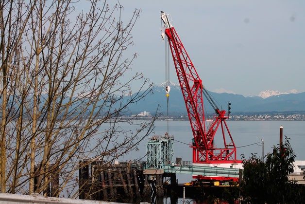 A crane helps workers install new counterweight cables at the Clinton Ferry Terminal on Monday.