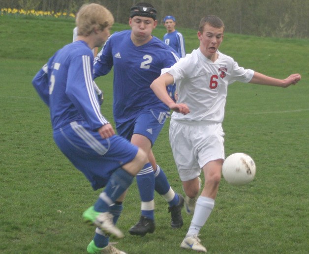 South Whidbey defenders Connor McCauley and Calvin Shimada trap Archbishop Murphy sophomore Kenny Ficklin near the sideline on April 5.