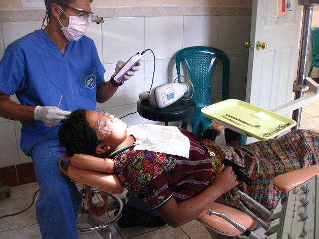 Dr. Braden Giswold attends to a dental patient at a Guatemala clinic recently.