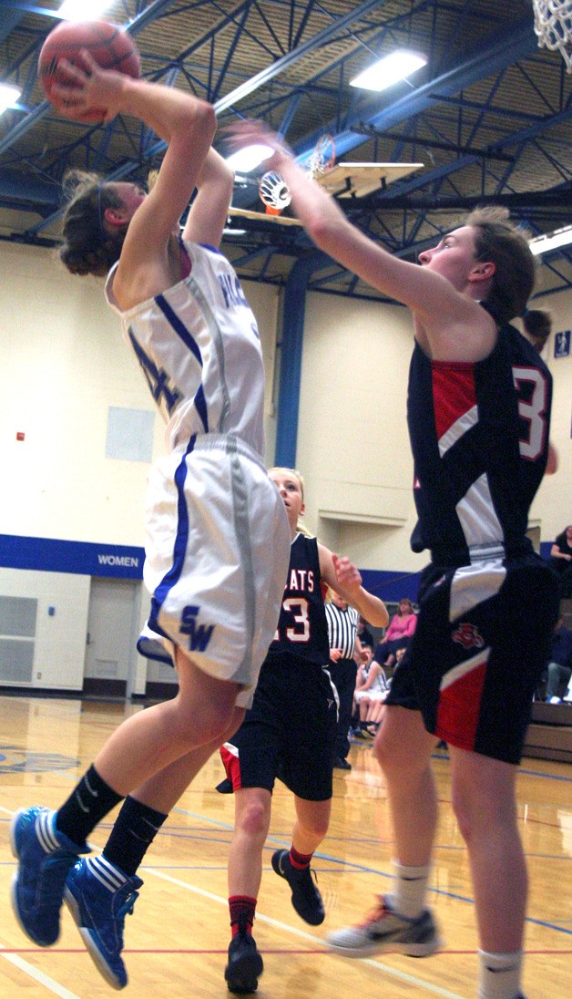 Falcon junior Ellie Greene shoots over Wildcat senior Anna Maher in the first quarter Tuesday night. Greene finished with a team-high 8 points in the loss.