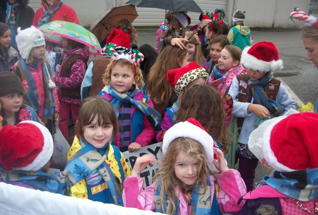 Clara Jurriaans and Carlie Kuschnereit of Daisy Troop 44127 are front and center as the Girl Scouts prepare for the Langley Holiday Parade. Despite a constant rain