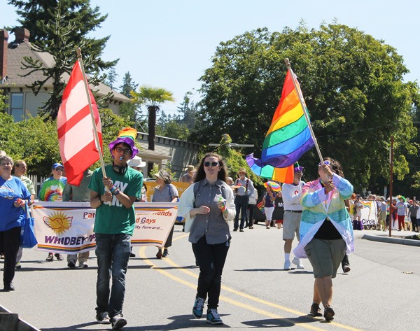 Members of the Whidbey PFLAG group hold marriage equality and gay pride flags.