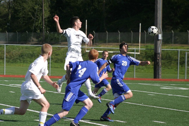 Dean Freundlich (20) tracks a header from Sean Ryan (10). Thomas White (24) cuts off Wildcat senior Stephen Briede.