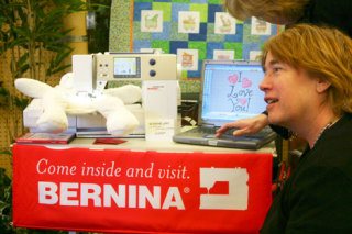 Casey's Crafts owner Laurie Davenport gets a demonstration of a new Bernina sewing machine that can be programmed to apply designs and text onto a pillow or stuffed animal. Casey's has recently started selling sewing machines and currently has three models of the Bernina brand in stock.