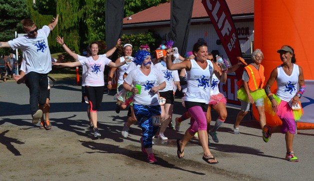 Runners from the team Cirque du Sore Legs cross the finish line of the 2013 Northwest Passage Ragnar Relay