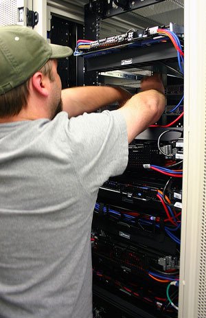 A Whidbey Telecom technician works on computer equipment Thursday to help fix an email problem that affected thousands of customers for nearly a week.
