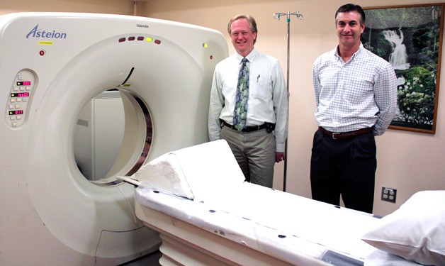 Chief Radiologist Dr. Robert Hawkins and Diagnostic Imaging Manager Randy White with Whidbey General Hospital’s old CAT scan machine. The new machine will reduce scan times and use a lower dose of radiation.