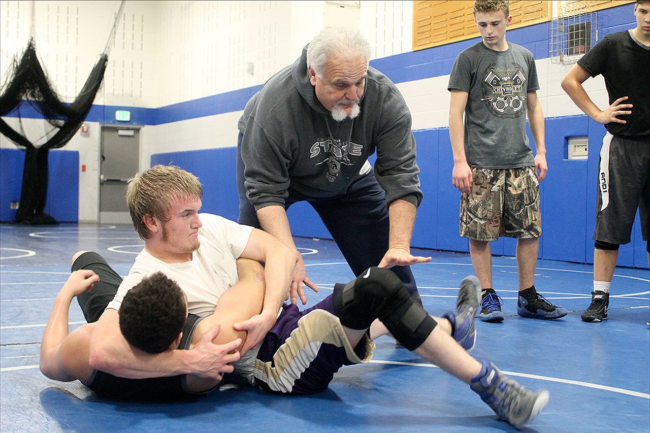Evan Thompson / The Record                                South Whidbey senior Hunter Newman and his father, assistant coach Paul Newman, demonstrate a pinning move at a practice Monday afternoon.