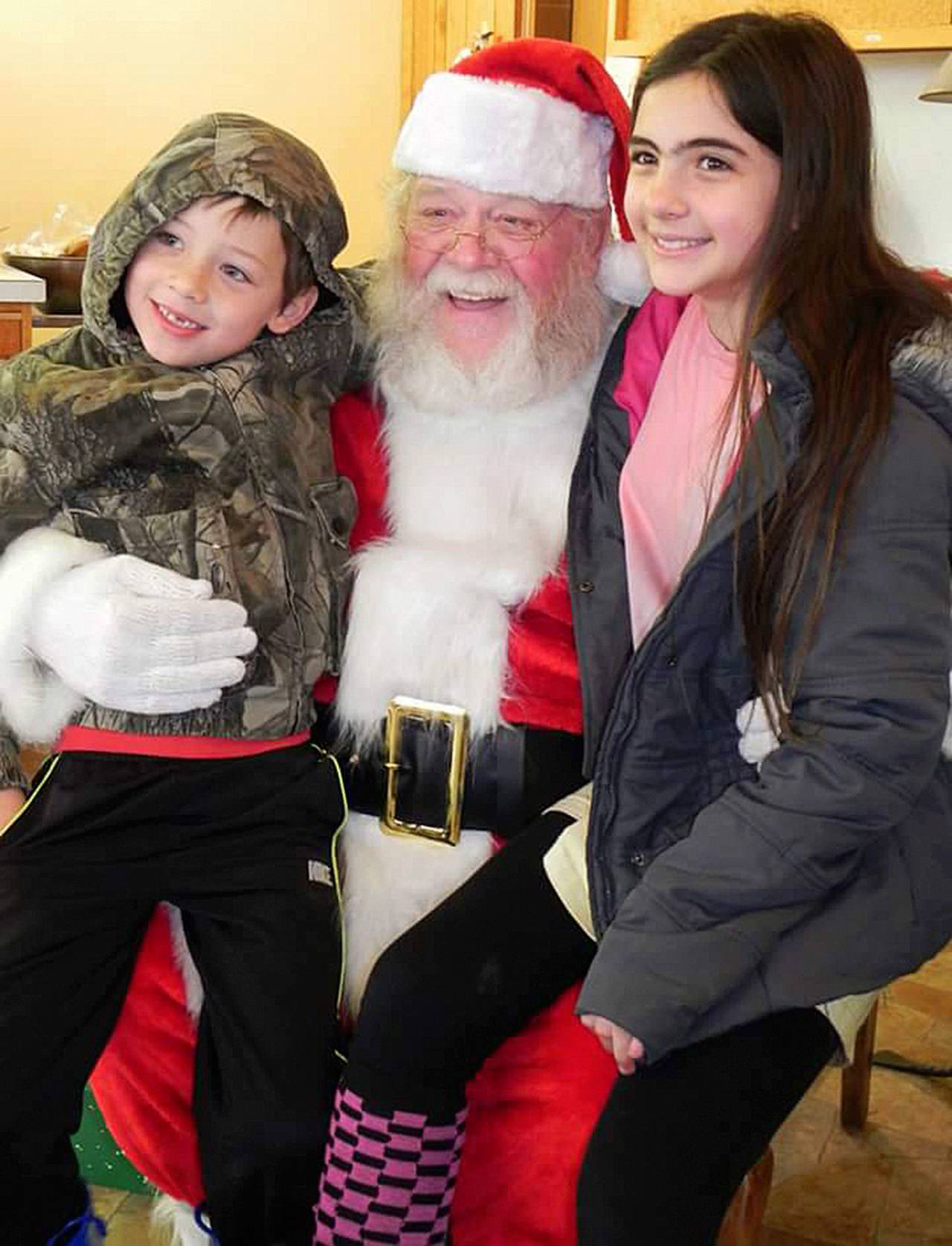 Contributed photo                                Santa poses with a couple of youngsters at a past Clinton Holiday Bazaar. Santa will return for free photos this year.