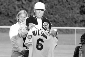 Colton Wilson holds up a jersey from former Mariner catcher Dan Wilson during the dedication of South Whidbey High School’s baseball field Friday; the thousands of dollars of improvements were made possible by the Make-A-Wish Foundation and local donors.
