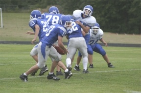 Blue team quarterback Hunter Rawls scrambles around the white team defense Saturday. The scrimmage