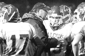 Defensive coordinator Damian Greene provides a pep talk to his lineman during a time out on the field Friday night. The defense prevented Cedarcrest from scoring offensively until the third quarter.