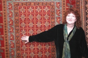 Sharon Lundahl stands before a recently acquisitioned replica of the famous “Pazyryck carpet” on display at Music for the Eyes in Langley.