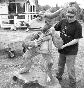 Chainsaw sculptor Adrian Robbins moves a sculpture on wheels back toward the building where it is stored at night. Robbins and two other artists who show their work at Clinton's Island Art lost a number of large pieces to thieves last week.