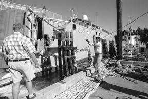 Matt Czarnik grabs for a mooring rope thrown onto the Nichols Brothers dock Friday by a crew member aboard the Army-Navy catamaran Joint Venture.