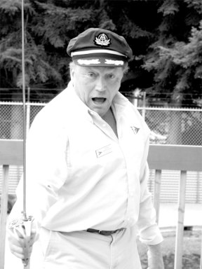 Newly commissioned Commodore Derek Pritchard prepares to repel boarders on the deck of the South Whidbey Yacht Club Sunday as the club celebrates boating season’s opening day.