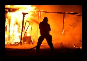 A District 3 firefighter battles a blazing house fire in the early morning hours Saturday in Clinton. The home was unoccupied and a total loss.