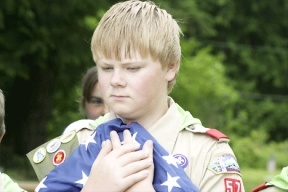 Boy Scout Colton Justus from Troop 57 carries the flag to the flagpole at the start of a Memorial Day remembrance ceremony Monday at Clinton Cemetery.