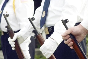Three American Legion Color Guards prepare to fire three rounds of shots during a flag changing ceremony outside the Langley Chamber of Commerce office.