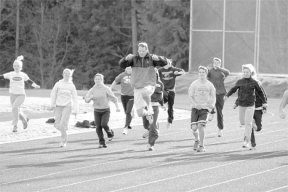 Assistant jumper coach Mark Eager demonstrates the fine art of lifting ones knees to members of the South Whidbey track team. They get their chance to show what they’ve learned at 3:45 p.m. March 16.