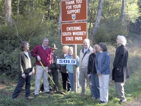 Representatives of the parties involved in the successful Wilbert Trail acquisition mark the new northern boundary of South Whidbey State Park. From left is Sue Ellen White of Save The Trees