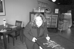 Kim Bailey is putting finishing touches on a board at her new deli