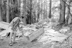 Leon Israel looks at five cubic yards of garbage and debris dumped on his property in Clinton.