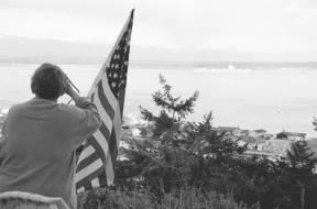A resident of Lagoon Point watches as the USS Abraham Lincoln moves through Admiralty Inlet about 6:45 a.m. Friday..