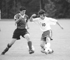 South Whidbey High School junior Roy Ishii dashes to maintain possession of the ball from a Nooksack Valley defender during South Whidbey's 8-1 win over the Pioneers Friday night.