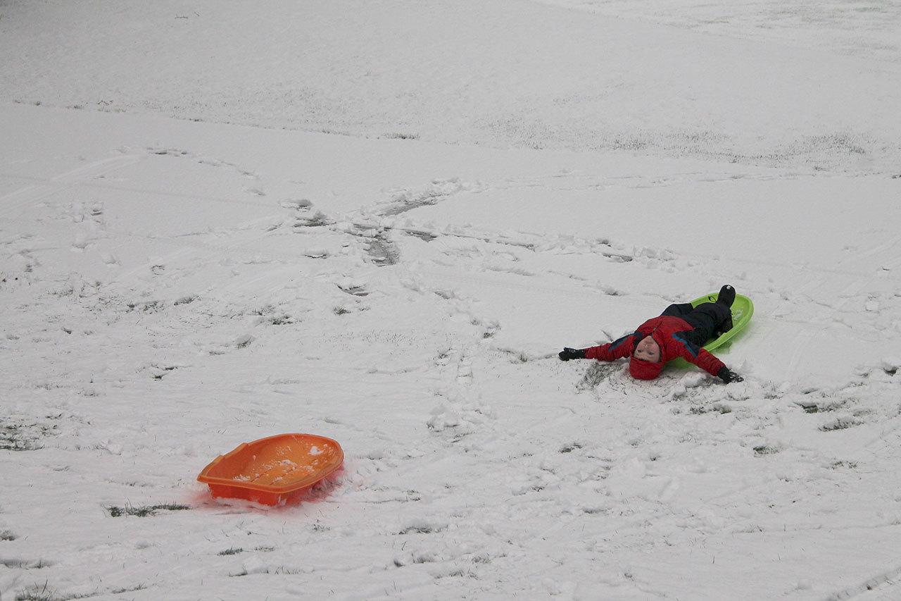 Kyle Jensen / The Record                                Dylan McKnight makes a snow angel after sledding downhill at Community Park.