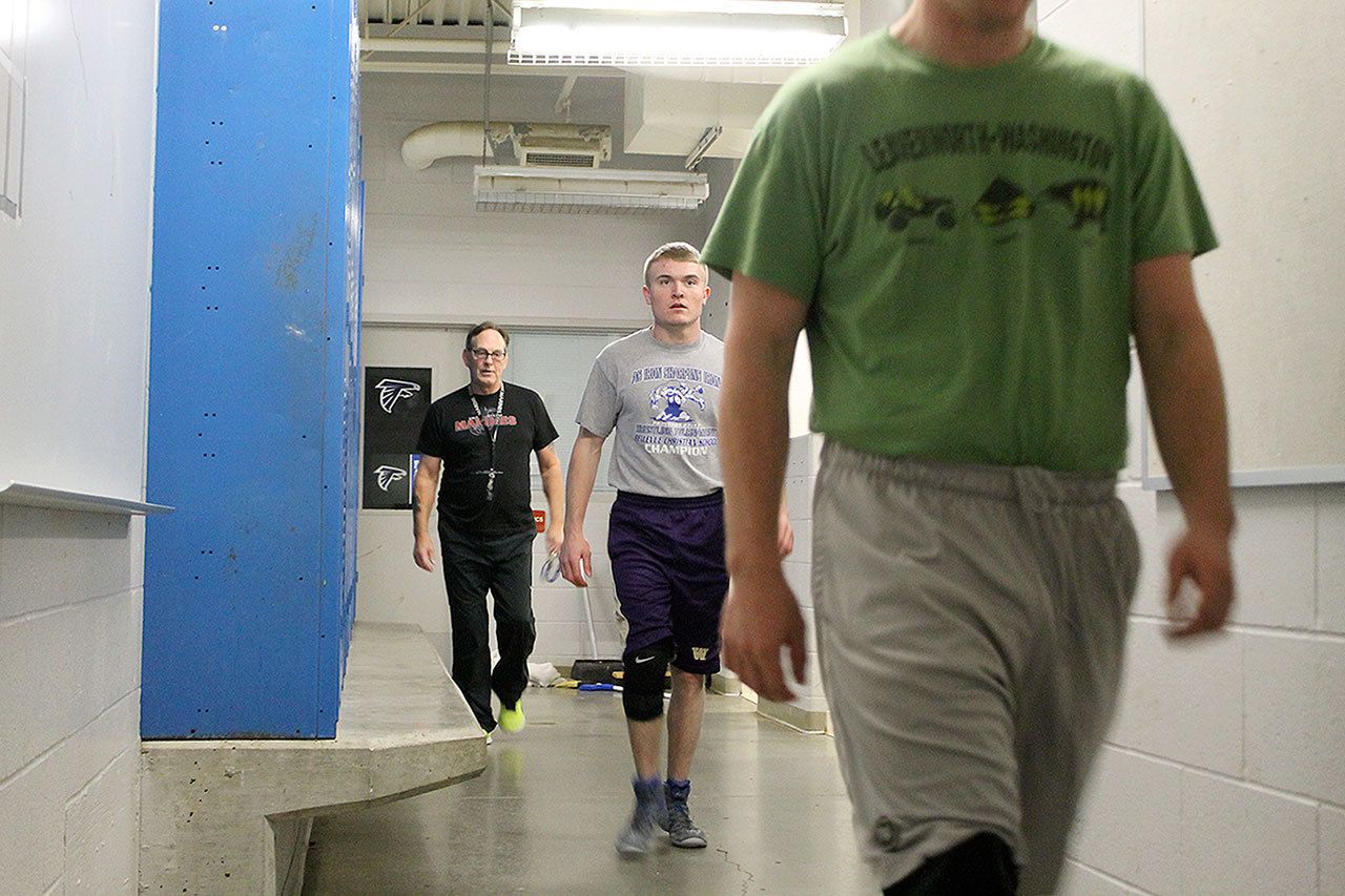 Evan Thompson / The Record                                Wrestlers Logan Madsen, Hunter Newman, and head coach Jim Thompson leave the boys athletic locker room and head off to practice Thursday afternoon. The locker room has been cold the last two years until the South Whidbey School District made repairs this week, though the fix is only temporary.