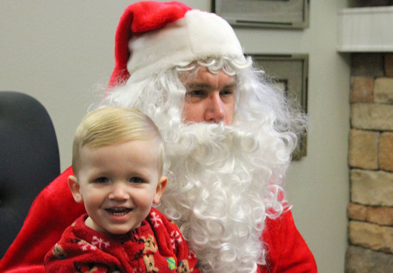 Kyle Jensen / The Record                                1-year-old Isaac Colbet sits on Santa’s lap at Maple Ridge Assisted Living in Freeland.