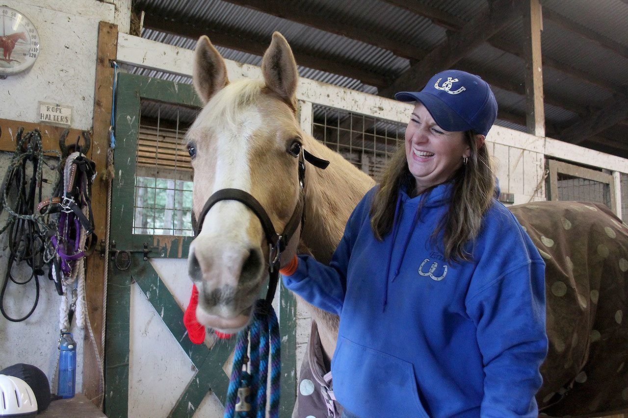 Kyle Jensen / The Record                                Whidbey Wranglers leader Erin Hanson laughs after Becca, a white Quarter Horse, seems happy after being brushed.