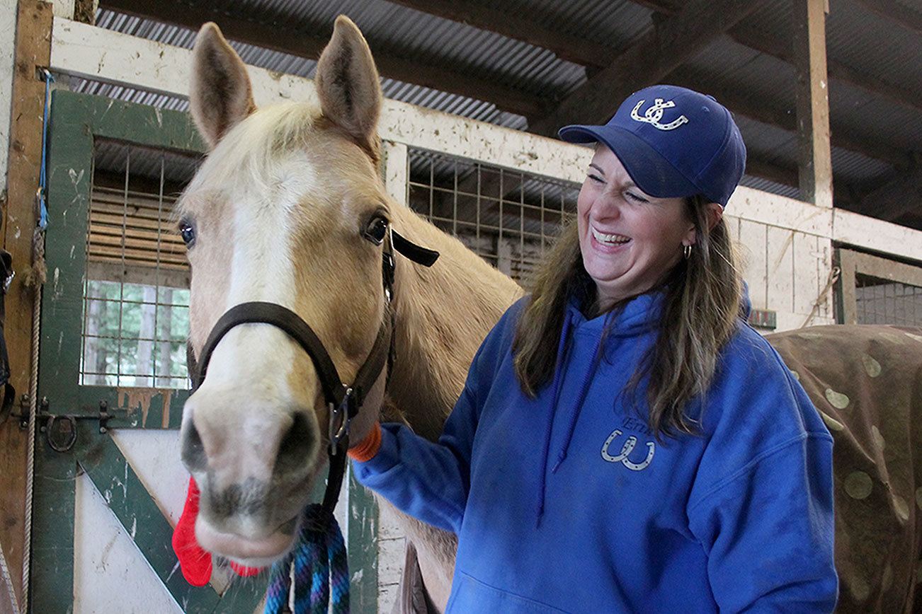 Kyle Jensen / The Record                                Whidbey Wranglers leader Erin Hanson laughs after Becca, a white Quarter Horse, seems happy after being brushed.