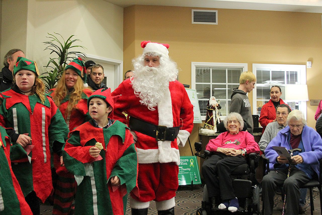 Kyle Jensen / The Record                                Santa and his elves sing Christmas carols in front of the crowd at Maple Ridge Assisted Living in Freeland.