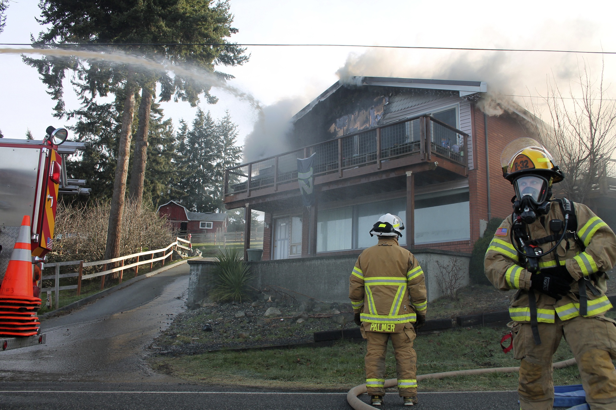 Kyle Jensen / The Record                                Firefighter Alex McMahon (right) scrambles to put out the fire while Chief Rusty Palmer oversees operations.