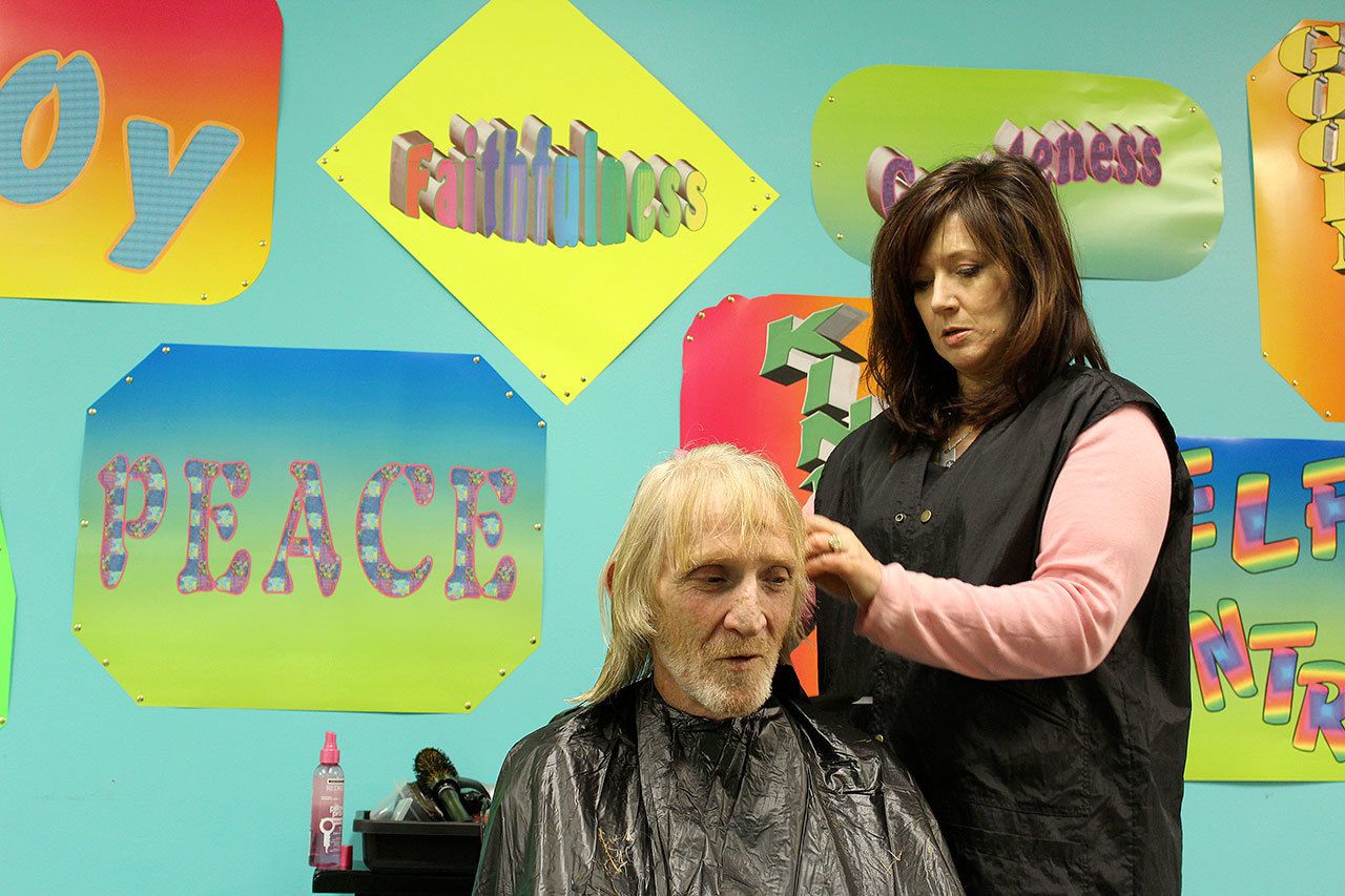 Stylist Spring Roehm trims the hair of Charles Jackson Thursday at Langley&rsquo;s Island Church. Free haircuts, a hot meal and other services were offered during the annual Homeless Point in Time count to encourage people in need of shelter to seek help. Volunteers also scoured Whidbey Island in search of the homeless.                                Photo by Patricia Guthrie/Whidbey News-Times