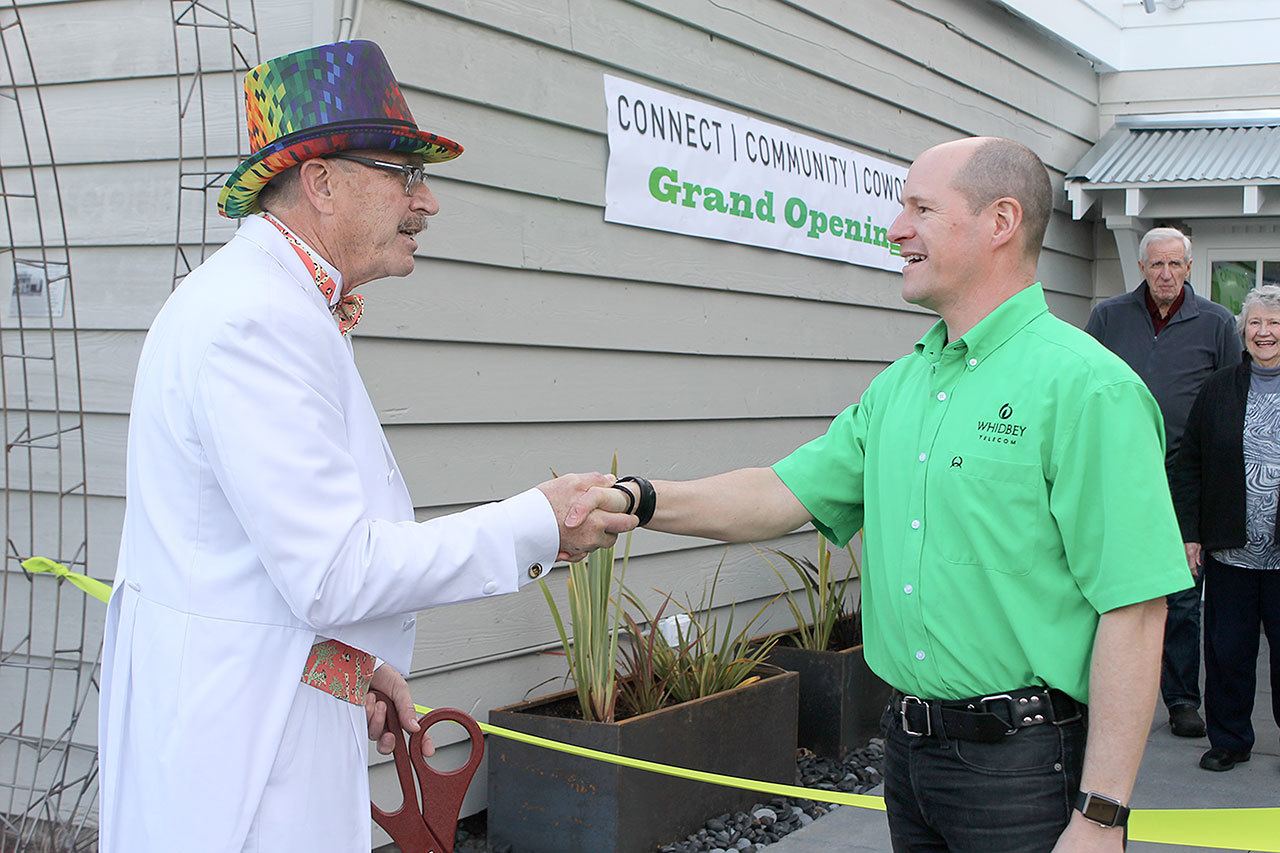 Evan Thompson / The Record — Mayor Tim Callison (left) shakes Whidbey Telecom co-CEO George Henny’s hand during a ribbon cutting for the cable company’s new satellite office, the BiG GiG Center.