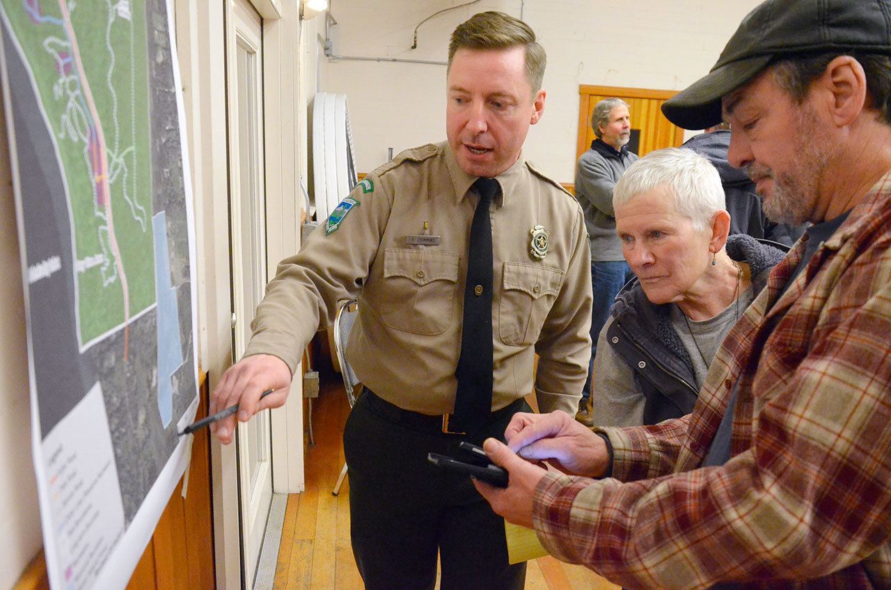 Justin Burnett / The Record                                 Jon Crimmins (left), area manager of Central Whidbey State Parks, speaks with Lagoon Point residents Louise Abbott (middle) and Dave Earp (right) about South Whidbey State Park at a public meeting Wednesday in Freeland.