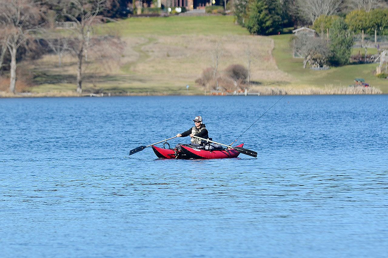 Justin Burnett / The Record — A fisherman paddles across Lone Lake on Monday afternoon. Bow fisherman will come to the lake in April to reduce a grass carp population that has reduced submerged plant communities and increased algae bloom.