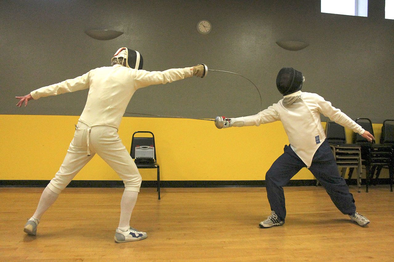 Kyle Jensen / The Record &mdash; Joseph Kleinman (left) beats Bob Tearse (right) to the point while sparring in epee.