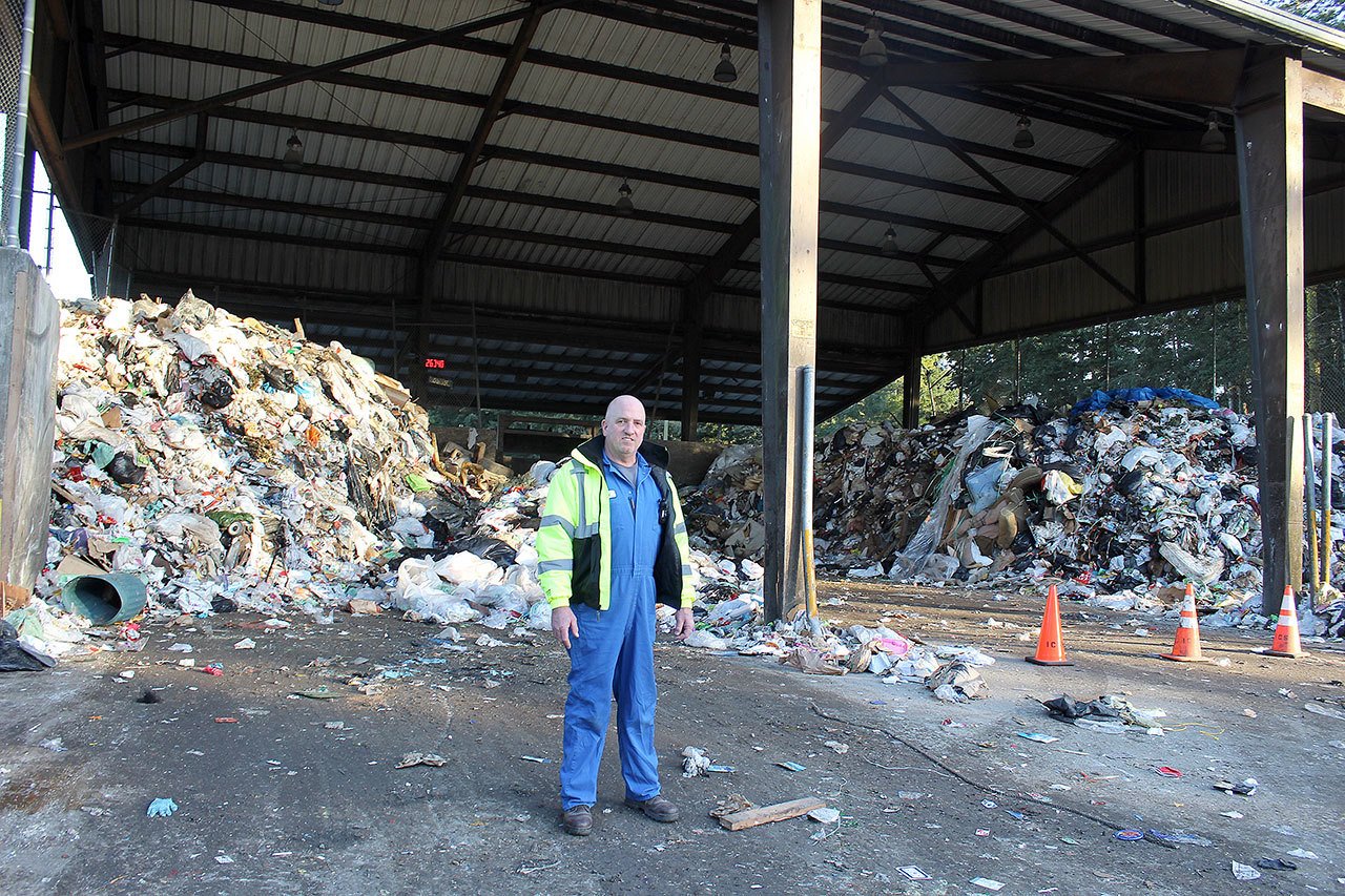 Patricia Guthrie/Whidbey News Group                                Todd Davis, lead technician at Island County’s Solid Waste Facility near Coupeville, stands in front of record heaps of garbage that is normally cleared out daily. It piled up because of an ice storm in southcentral Washington last month.