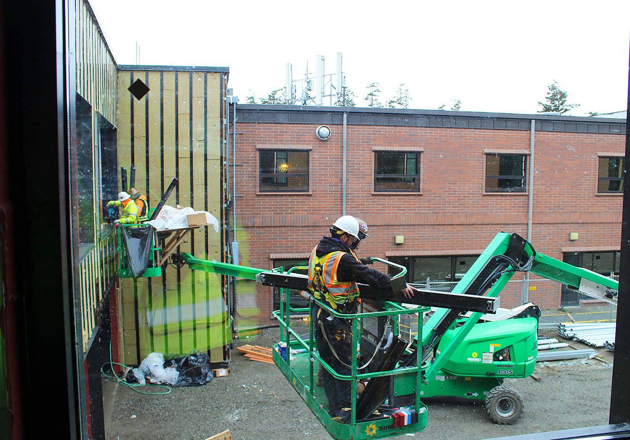 Construction workers at WhidbeyHealth Medical Center build the corridor that connects the old hospital to the $50million addition. The 60,000-square-foot wing features 39 private patient rooms and many design elements forinfection control and privacy. Photo by Patricia Guthrie/Whidbey News-Times