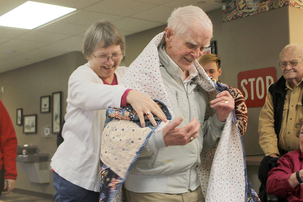 Evan Thompson / The Record — Ron Wadsworth, a 93-year-old Marine Corps veteran, receives a quilt from Quilts for Veterans coordinator Anita Smith. Wadsworth was one of nearly two dozen other veterans to receive quilts in gratitude of their service on Thursday at Maple Ridge Retirement and Assisted Living Community in Freeland.