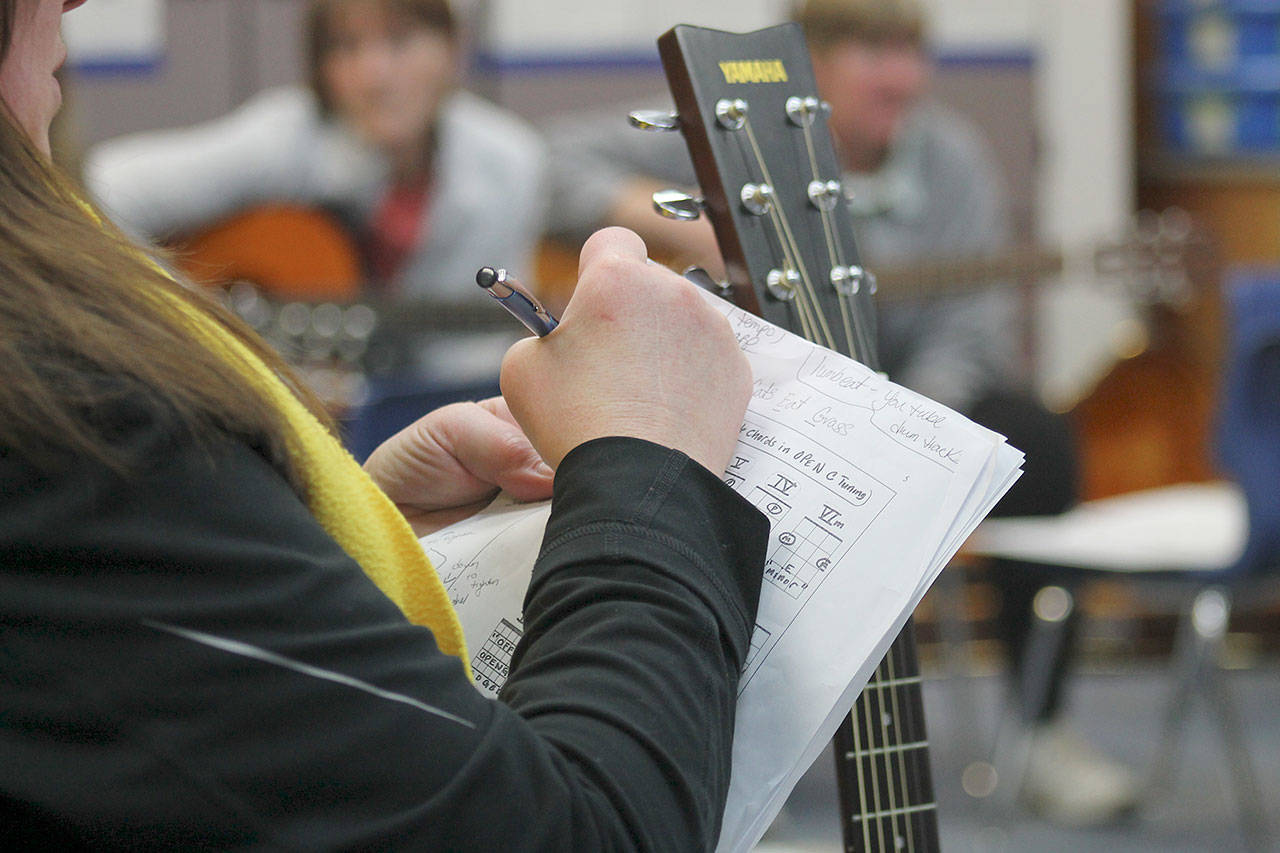 Evan Thompson / The Record — Paraprofessional Lori Chiarizio writes notes onto her music sheet at a practice session on March 7 inside South Whidbey Elementary School’s music room.