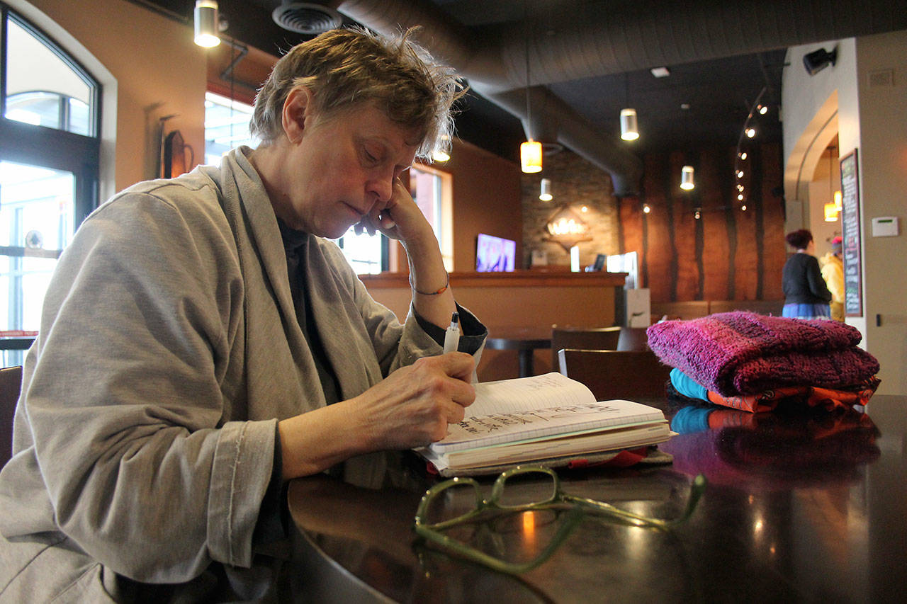 Kyle Jensen / The Record &mdash; Mary Anne Radmacher jots down thoughts at WiFire Coffee Bar, a place where she can typically be found working.