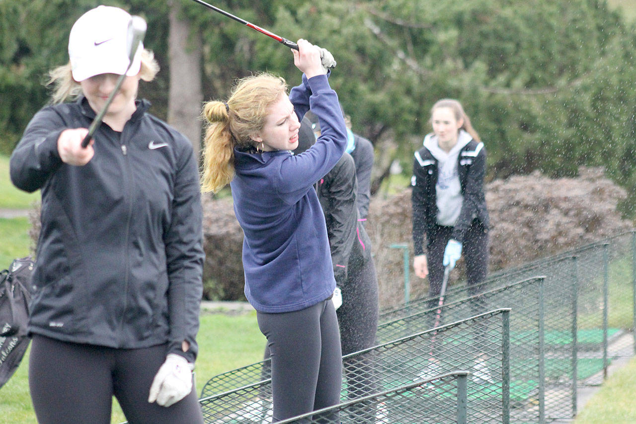 Evan Thompson / The Record — South Whidbey senior girls golfer Riley Yale (blue sweatshirt) hits a shot at the Useless Bay Golf and Country Club driving range at a recent practice.